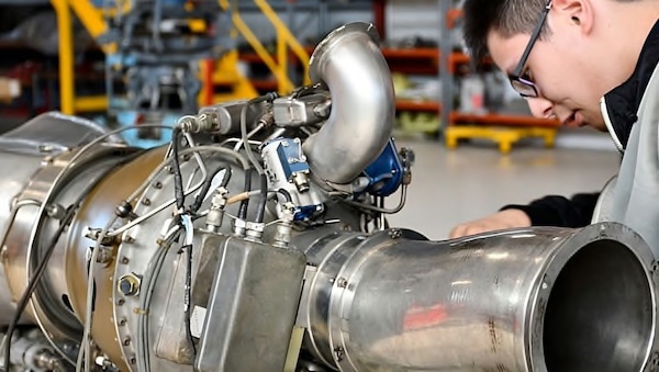 Apprentice engineer works on an aircraft engine  component